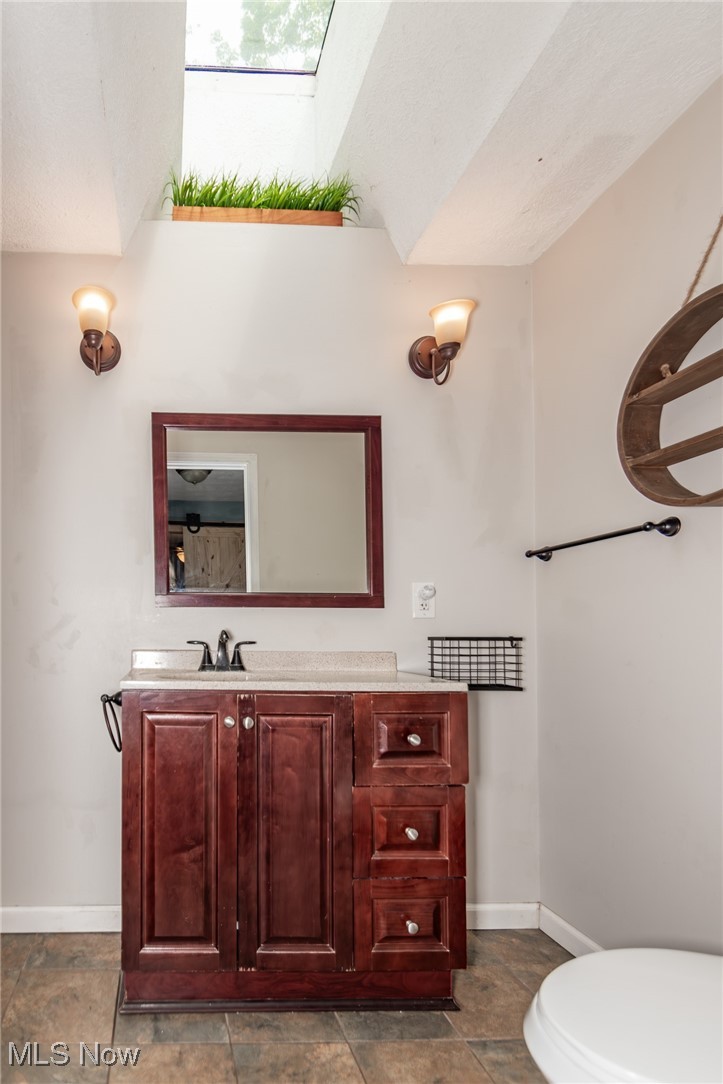 9723 Thwing Road Chardon, OH 44024 - Photo 31 of 42 Half bath featuring vanity and a skylight