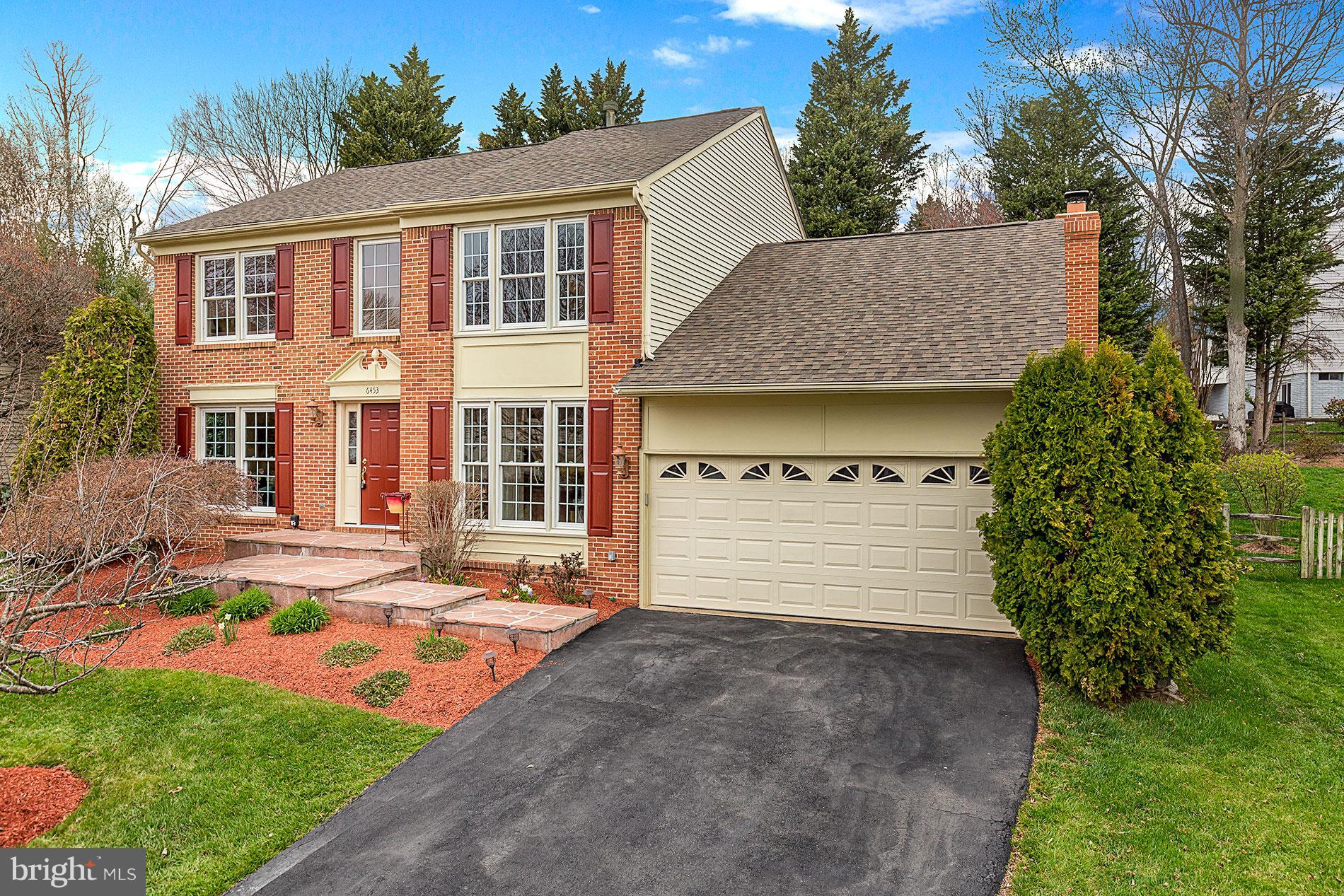 6453 Springhouse Circle Clifton, VA 20124 - Photo 2 of 30 a front view of a house with a yard and garage