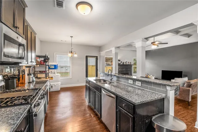 a kitchen with granite countertop a stove and a wooden floor