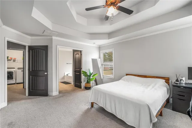 a bedroom with a large bed and a chandelier