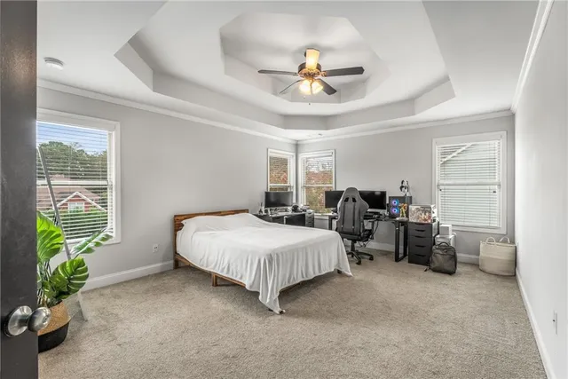 a spacious bedroom with a bed and ceiling fan