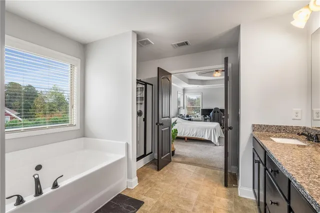 a en suite bathroom with a granite countertop tub and a sink