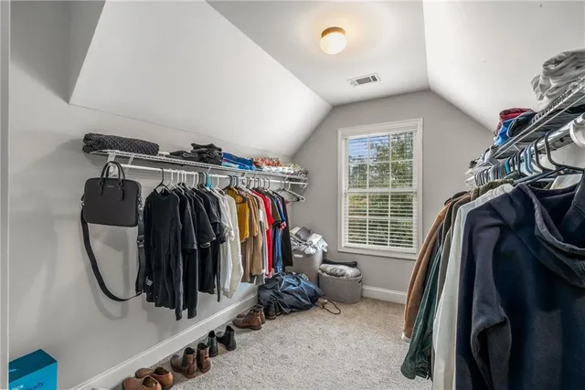 a view of walk in closet with clothes and shoes
