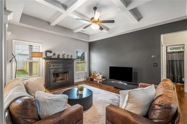a living room with furniture a fireplace and a ceiling fan