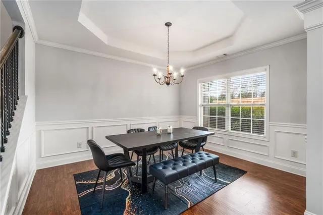 a dining room with furniture a chandelier and wooden floor