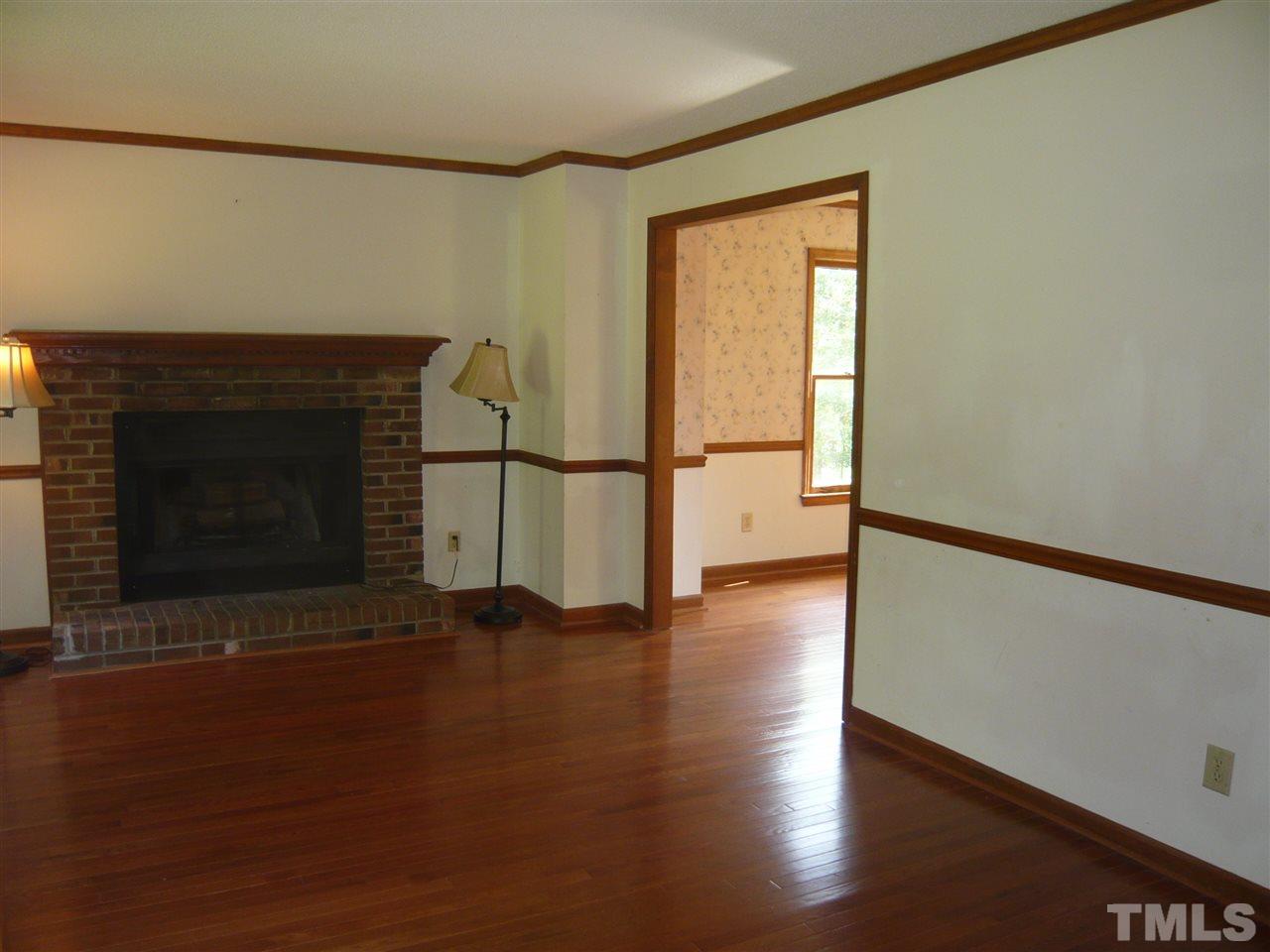 7301 Buck Road Wendell, NC 27591 - Photo 11 of 25 a view of empty room with wooden floor and fireplace