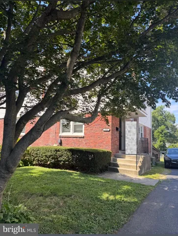 a view of a house with a tree in front of it