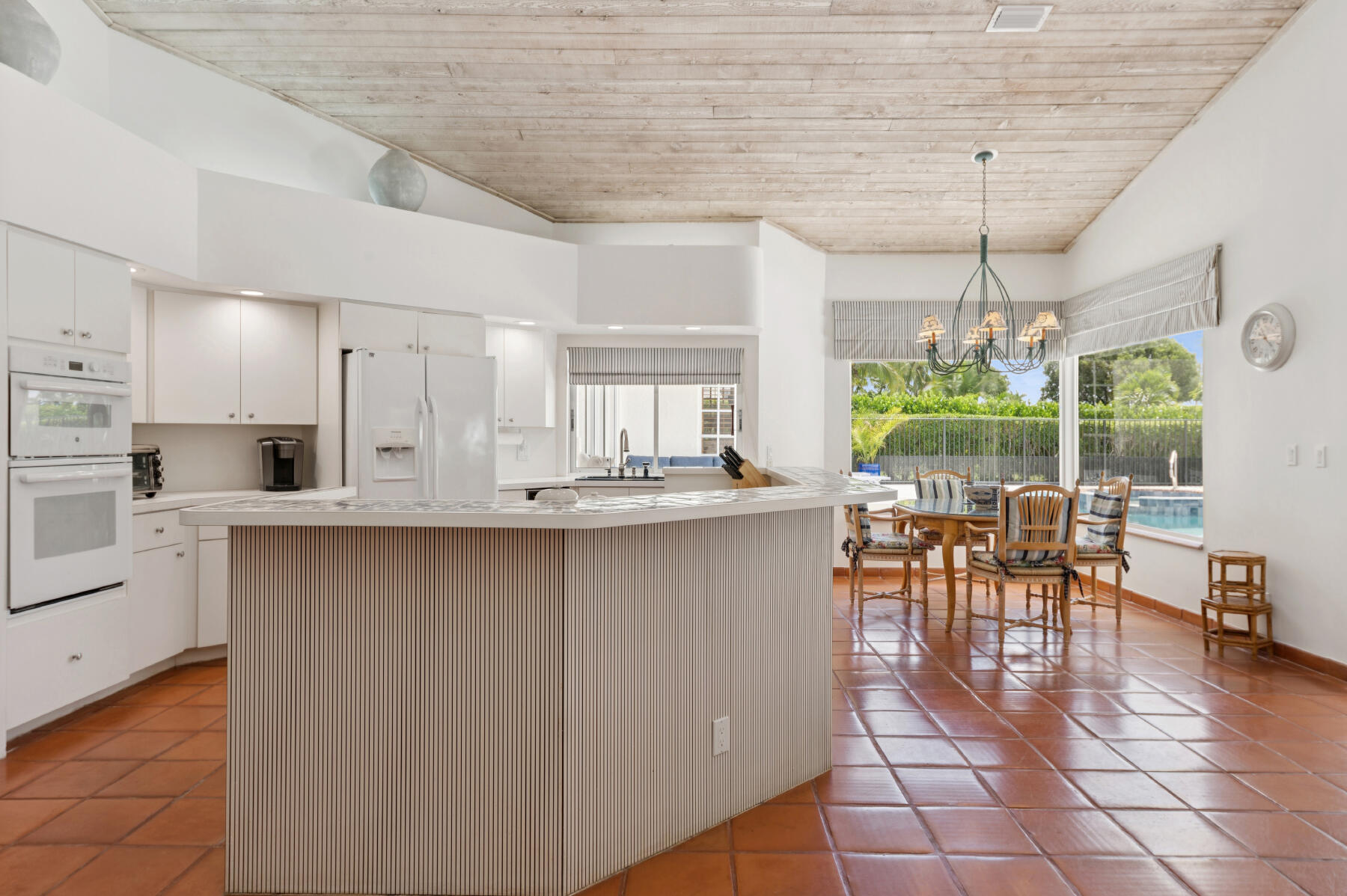 10403 Stonebridge Boulevard Boca Raton, FL 33498 - Photo 11 of 51 an open kitchen with granite countertop a stove a sink a dining table and chairs with wooden floor