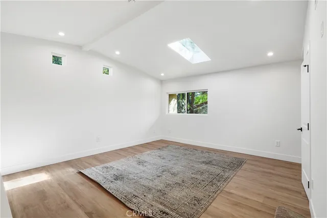 an empty room with wooden floor and window