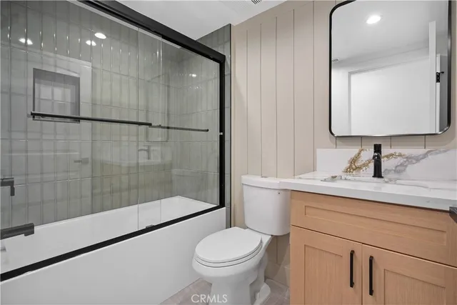a bathroom with a granite countertop sink a toilet and a mirror