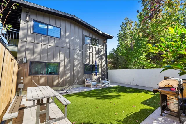 a view of swimming pool with lawn chairs and plants