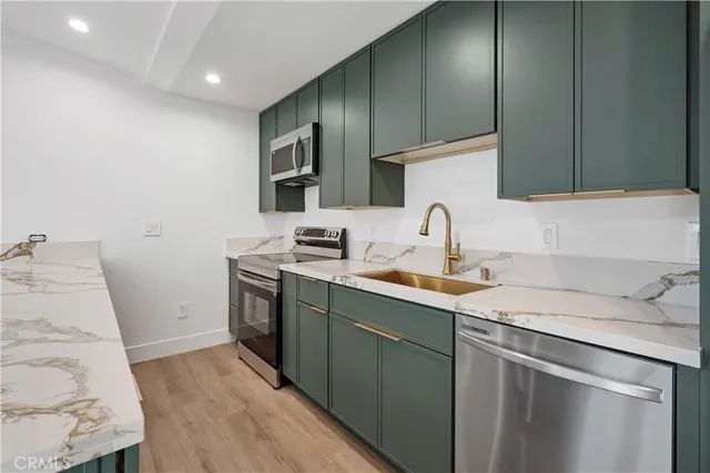a kitchen with a sink cabinets and stainless steel appliances