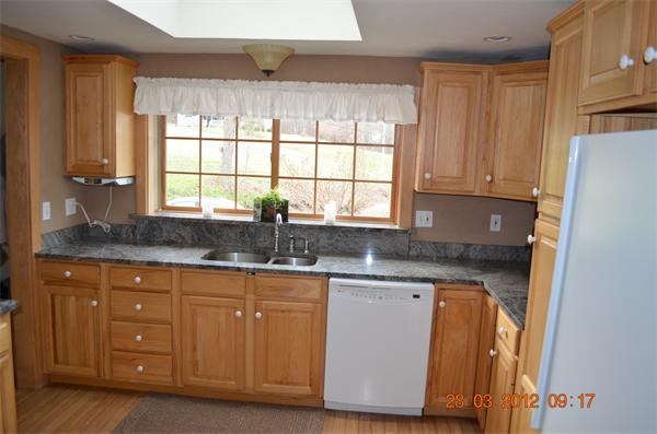 181 Butler Road Monson, MA 01057 - Photo 14 of 24 a kitchen with granite countertop wooden cabinets a sink and a window