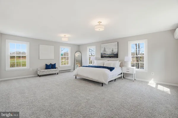 a spacious bedroom with a bed a table and a large window