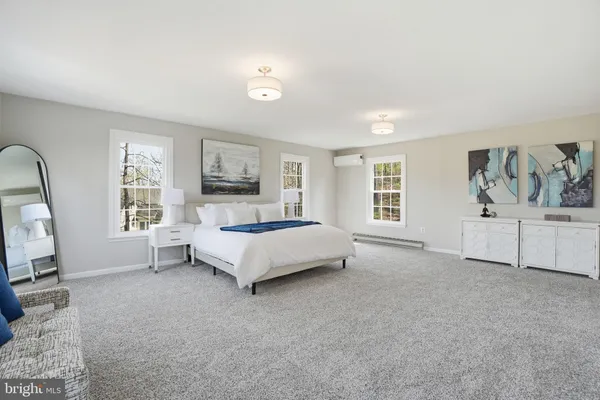 a spacious bedroom with a bed a couch and large window