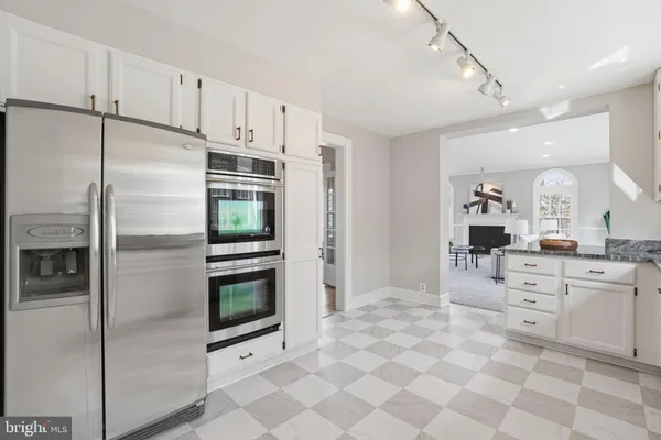 a kitchen with stainless steel appliances kitchen island granite countertop a refrigerator and a sink