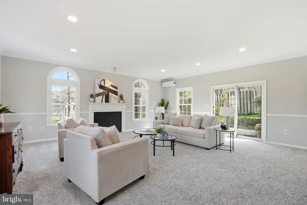 a living room with furniture a fireplace and a large window