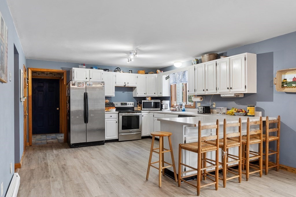 164 Sterling Road Princeton, MA 01541 - Photo 11 of 36 a kitchen with refrigerator and white cabinets