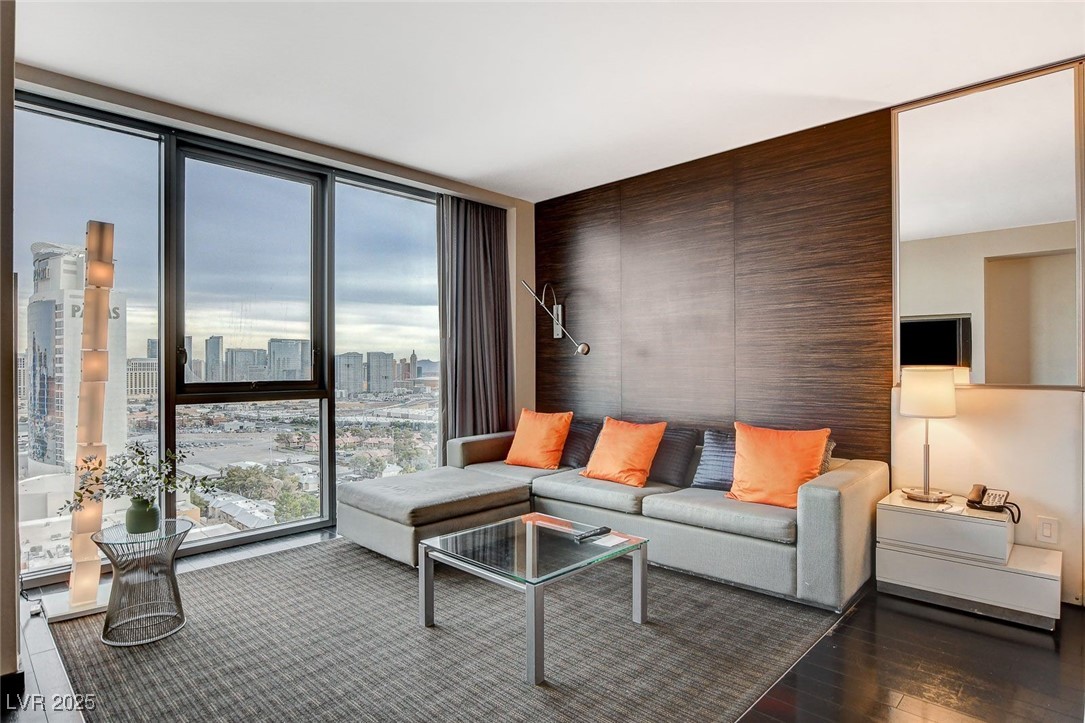 4381 West Flamingo Road, Unit 2204 Las Vegas, NV 89103 - Photo 8 of 27 Living area featuring expansive windows and wood finished floors