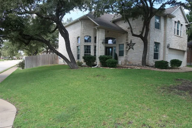 a view of a house with a yard and tree s