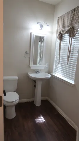 a bathroom with a toilet sink and mirror