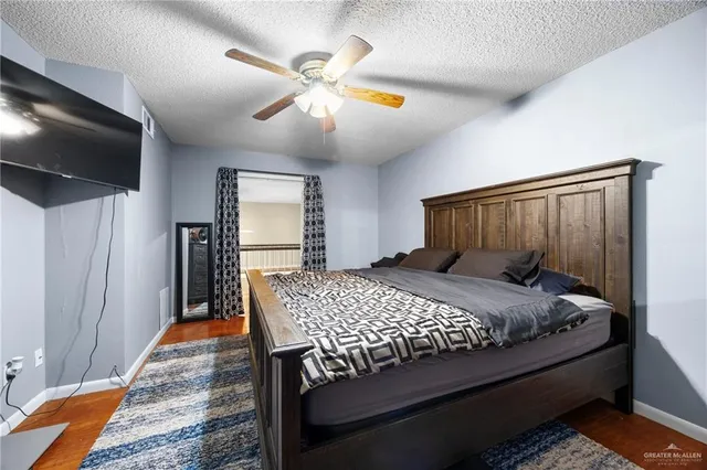 a bedroom with a bed table and flat screen tv