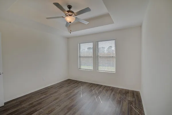 an empty room with a window and a fan