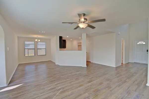 a view of an empty room with window and wooden floor