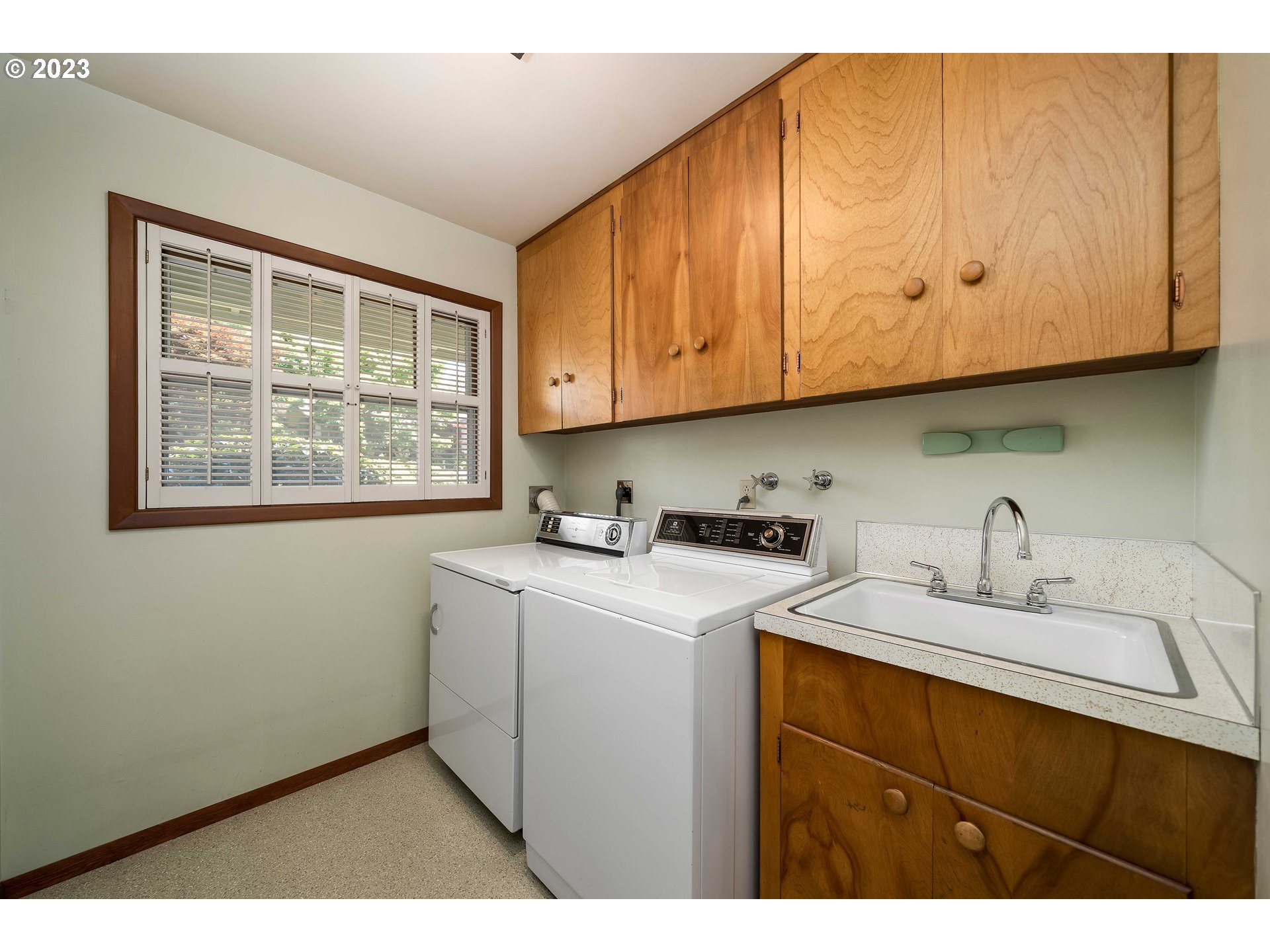 3815 Southwest 50th Avenue Portland, OR 97221 - Photo 17 of 36 a utility room with cabinets washer and dryer