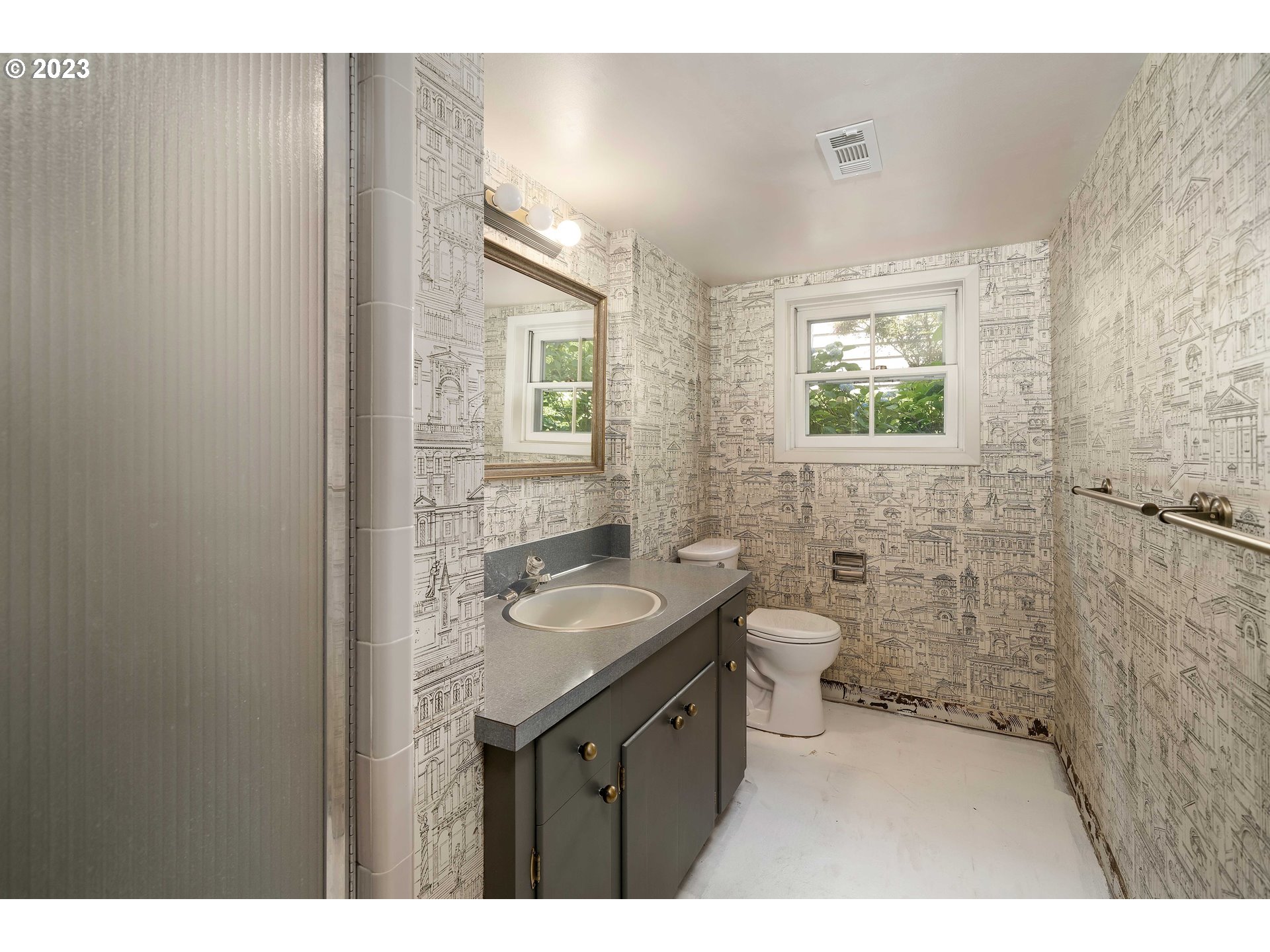 3815 Southwest 50th Avenue Portland, OR 97221 - Photo 21 of 36 a bathroom with a granite countertop sink a toilet a mirror and shower
