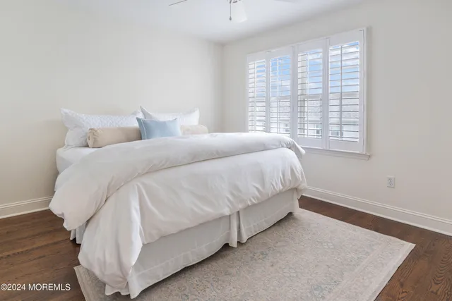 a large white bed in a room next to a window