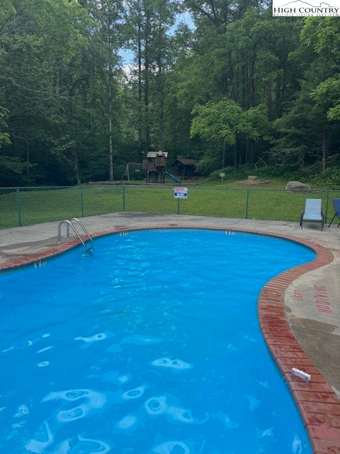 10 Cabin Ridge Road Ferguson, NC 28624 - Photo 10 of 12 a view of a swimming pool and a yard in the background