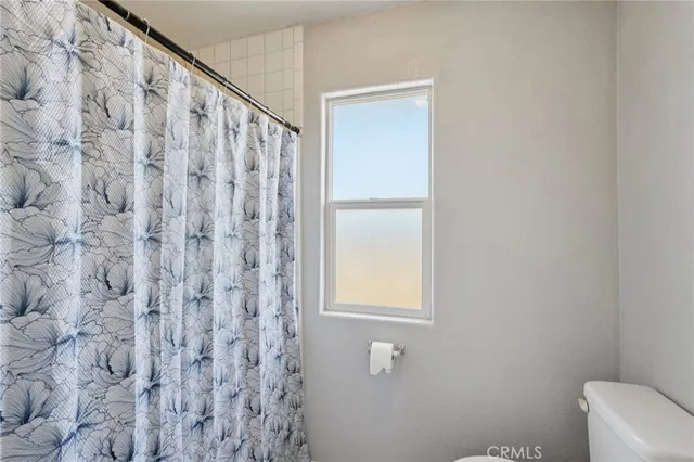 a bathroom with a shower curtain and a window