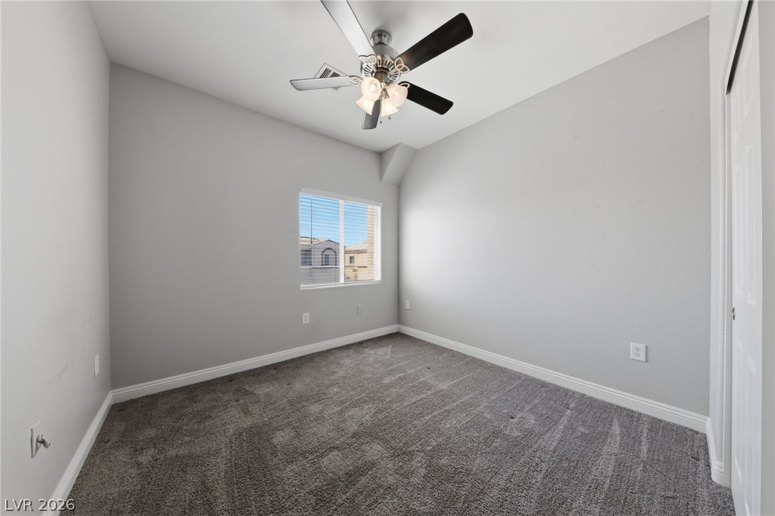 6312 Sandy Ridge Street, Unit 3102 North Las Vegas, NV 89081 - Photo 21 of 31 A well-lit bedroom features plush carpeting and a modern ceiling fan, offering comfort and convenience.