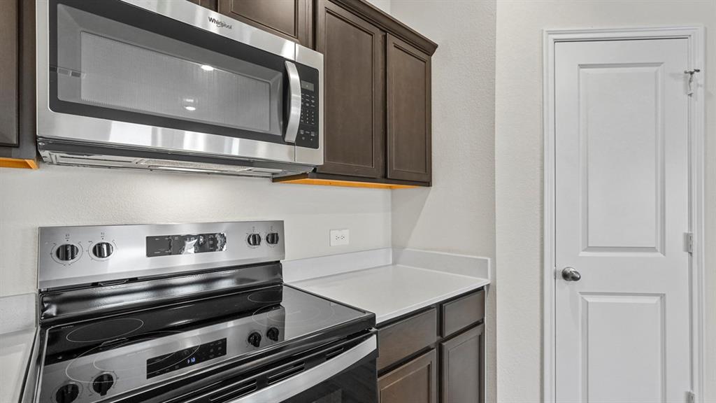 1953 Freeman Street Tyler, TX 75704 - Photo 7 of 32 Stainless steel microwave and electric range with a dark wood-finish cabinetry