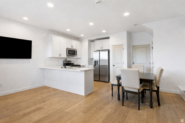 3473 Hardman Way Lehi, UT 84048 - Photo 4 of 22 Kitchen featuring white cabinets, stainless steel appliances, a peninsula, light wood-type flooring, and recessed lighting