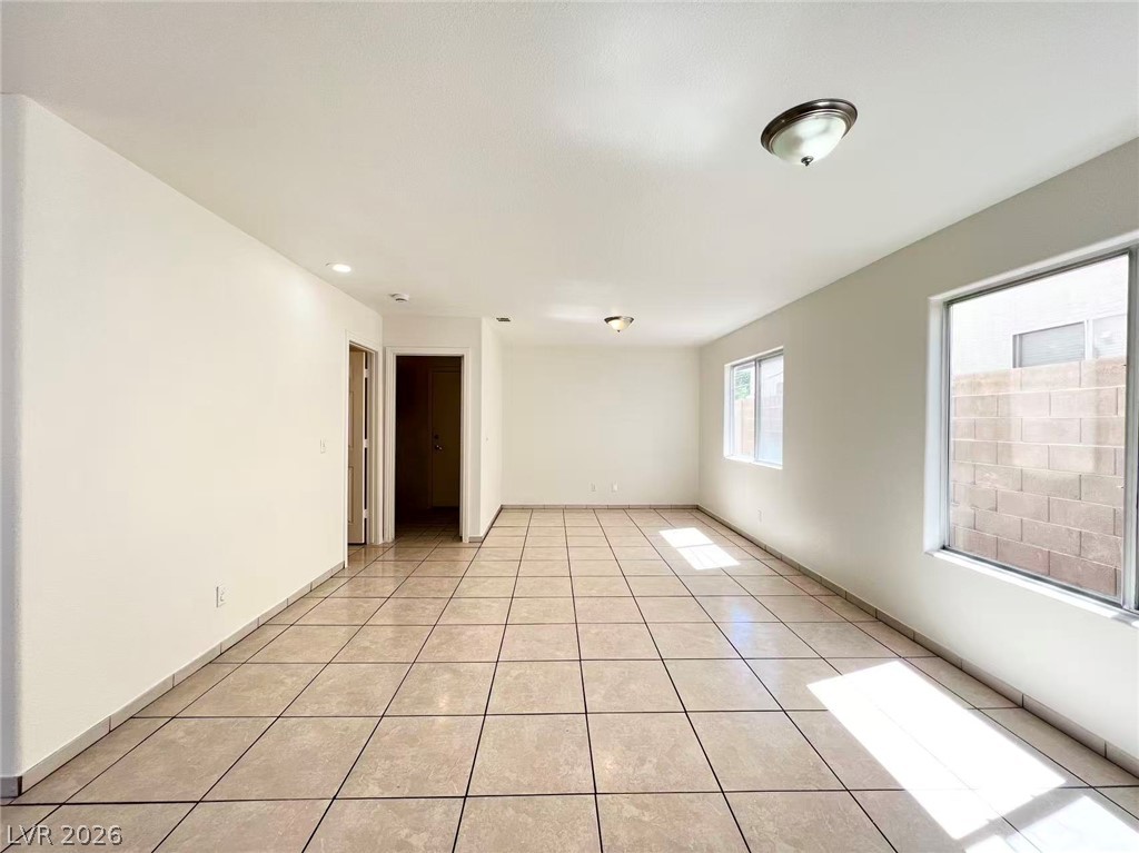 8284 West Rochelle Avenue Las Vegas, NV 89147 - Photo 5 of 29 A spacious, naturally illuminated living area features light-colored tile flooring and ample natural light from multiple windows.