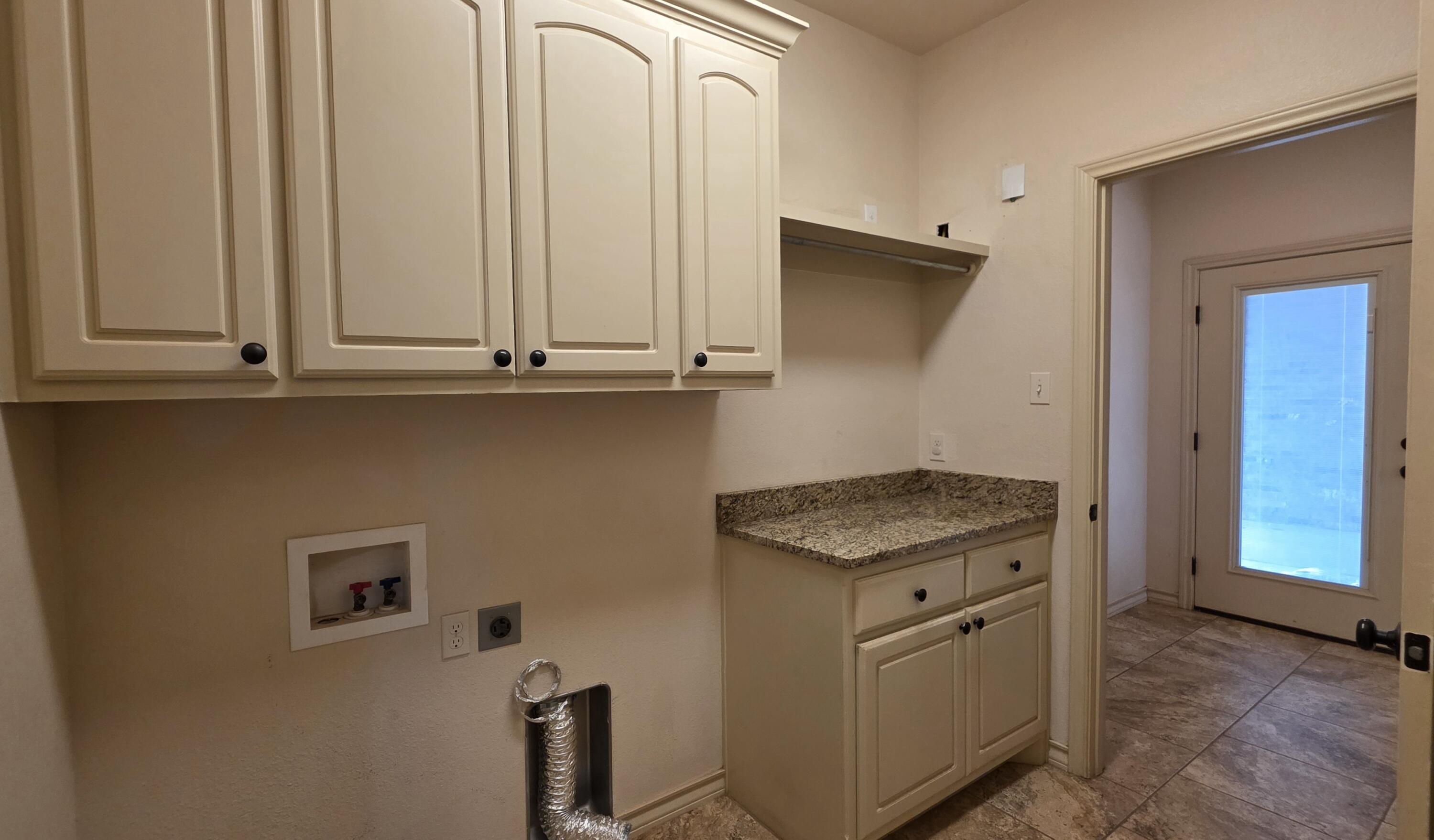 5234 Kemper Street Lubbock, TX 79416 - Photo 25 of 28 a kitchen with white cabinets and a stove