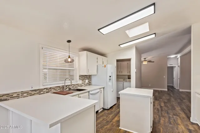 a kitchen with a sink appliances cabinets and a counter top space