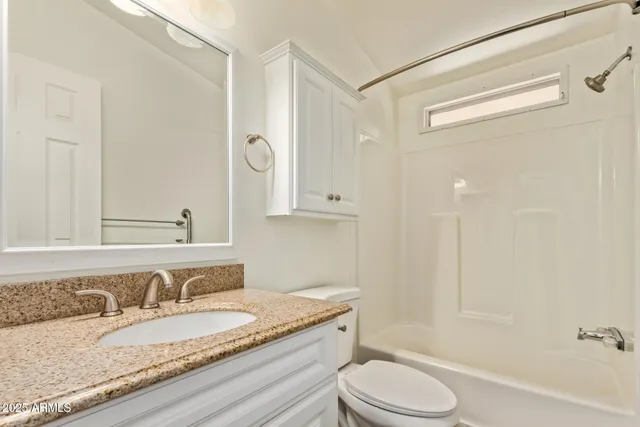 a bathroom with a granite countertop sink toilet a mirror and shower