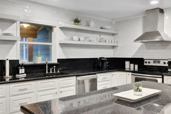 a kitchen with stainless steel appliances a sink a stove and cabinets