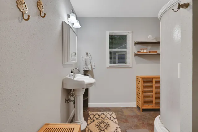 a bathroom with a sink a toilet and shower