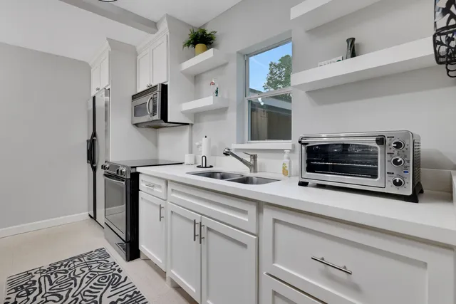 a kitchen with stainless steel appliances white cabinets and a stove top oven
