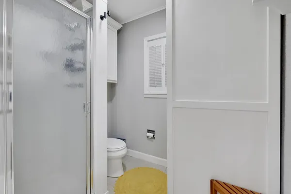 a bathroom with a granite countertop toilet and a shower