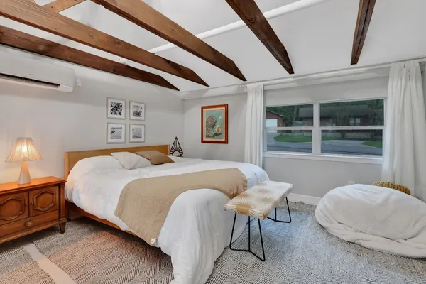 a spacious bedroom with a bed and a window