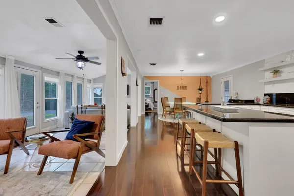 a living room with furniture a wooden floor and a sink