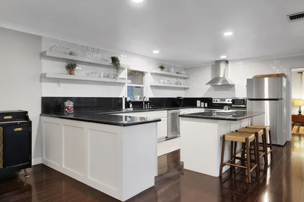 a kitchen with a refrigerator a stove a sink and a microwave