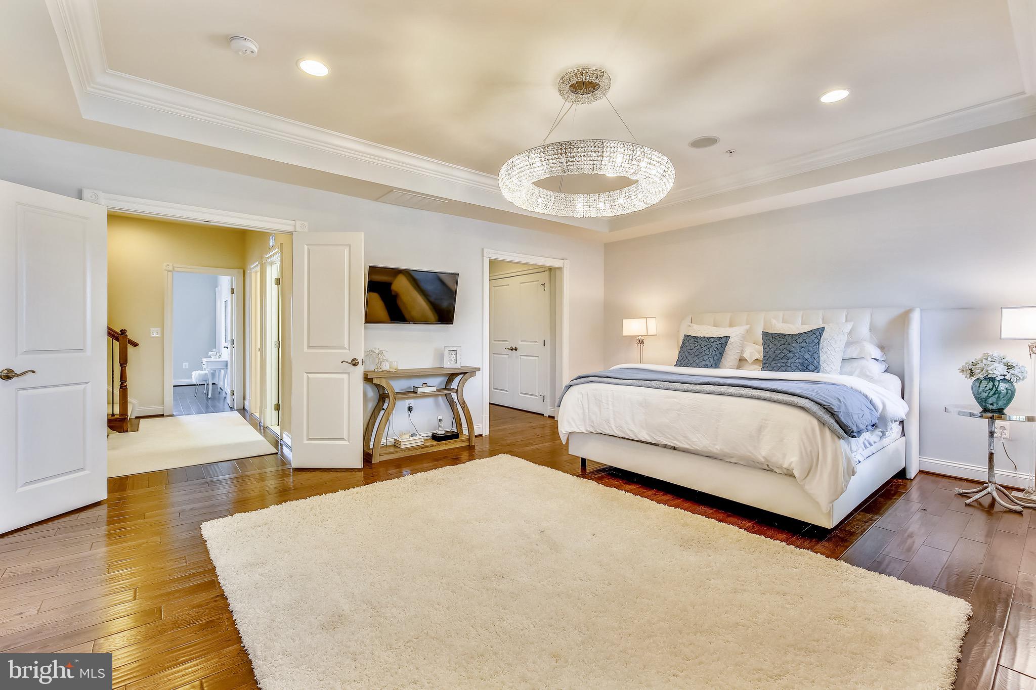 1411 Ridgeview Way Washington, DC 20007 - Photo 17 of 43 a spacious bedroom with a bed and a chandelier