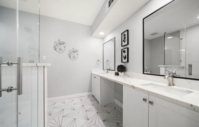 a bedroom with a bed next to a window with a chandelier