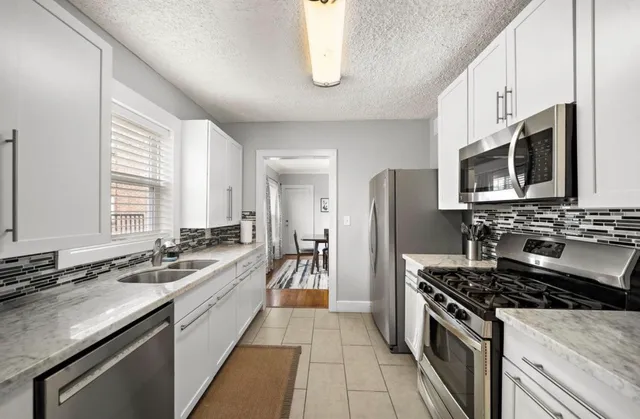 a large kitchen with a sink and refrigerator